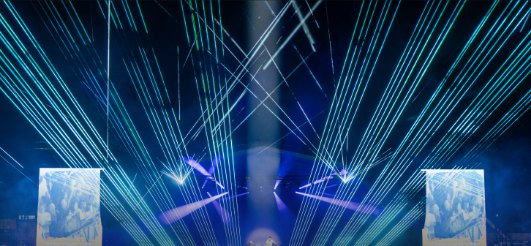 Blue laser fans above a stage